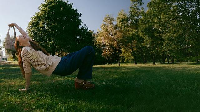 a woman laying on her back in a field of grass
