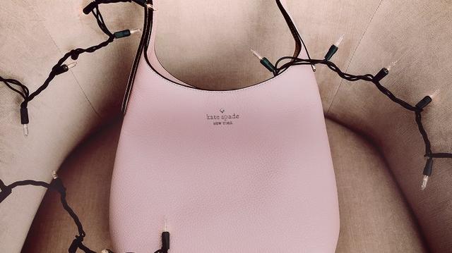 a pink purse sitting on top of a chair with lights around it