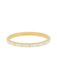 Gold-tone bangle bracelet with white pearl-like inlay detail around the outer edge.