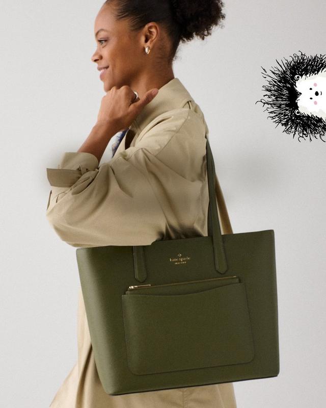 a woman is walking with a green purse in her hand