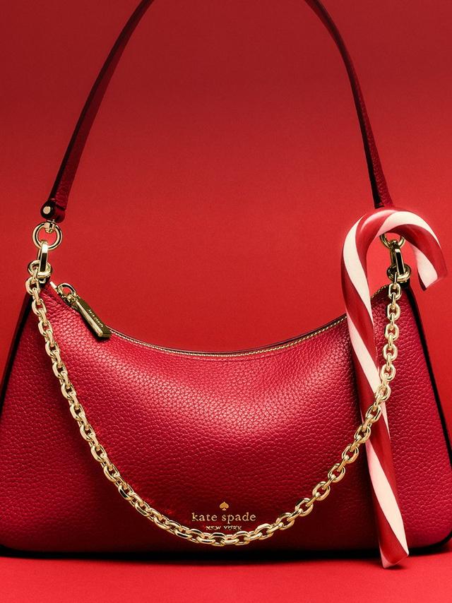 Red Kate Spade leather shoulder bag with gold chain strap and candy cane accent.