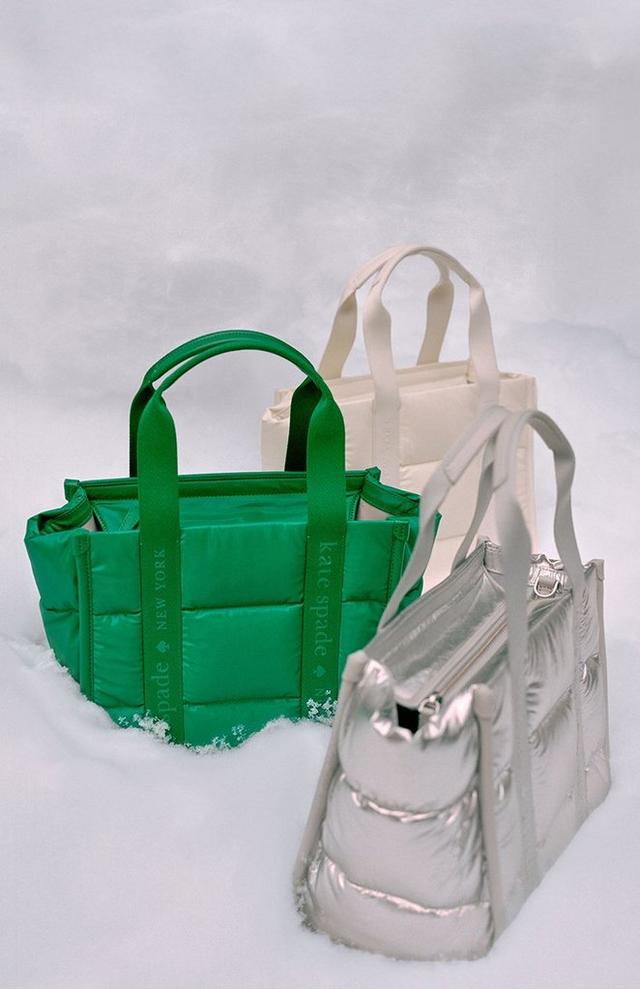 three bags of different colors are sitting in the snow