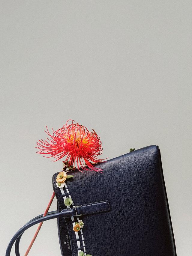 a close up of a purse with a flower attached to it