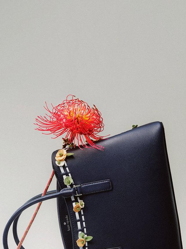 a close up of a purse with a flower attached to it