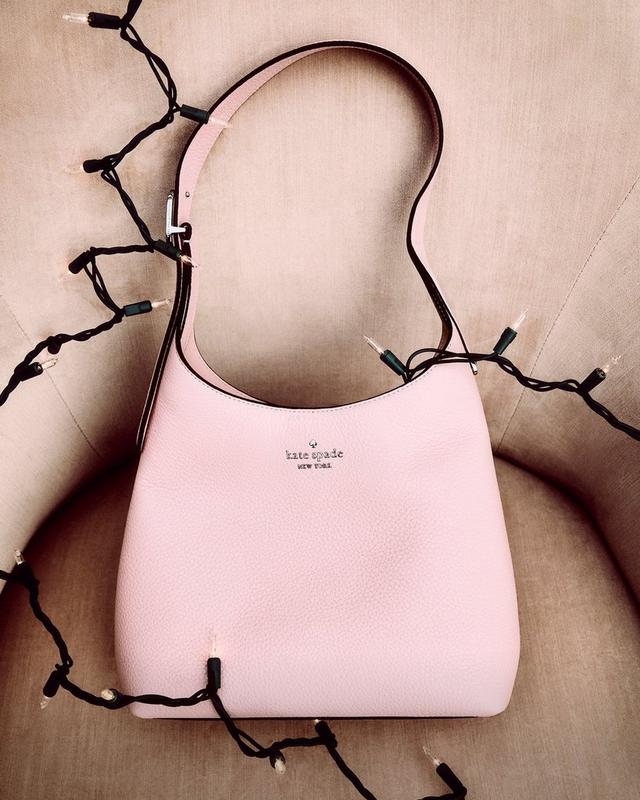 a woman is holding a large black bag in her hand