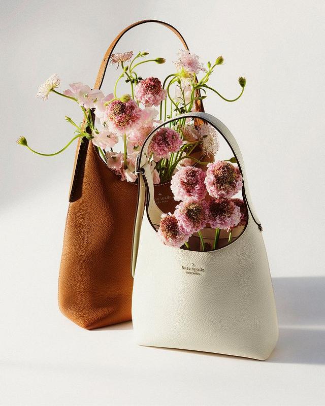 two small bags with flowers in them sitting on a table