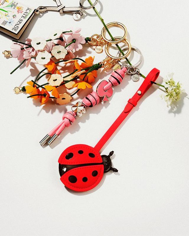 a ladybug keychain and a flower keychain are sitting on top of a table