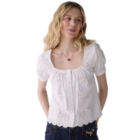 Woman wearing a white peasant-style blouse with short puff sleeves and gathered neckline.